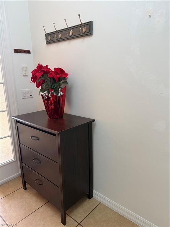 Entryway featuring neutral wall paint, a built-in coat rack, and ceramic tile flooring