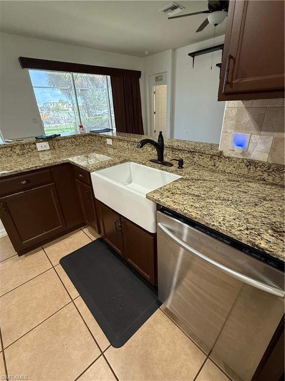 Kitchen featuring a white farmhouse sink with a matte black faucet, speckled stone countertops, and brown cabinetry