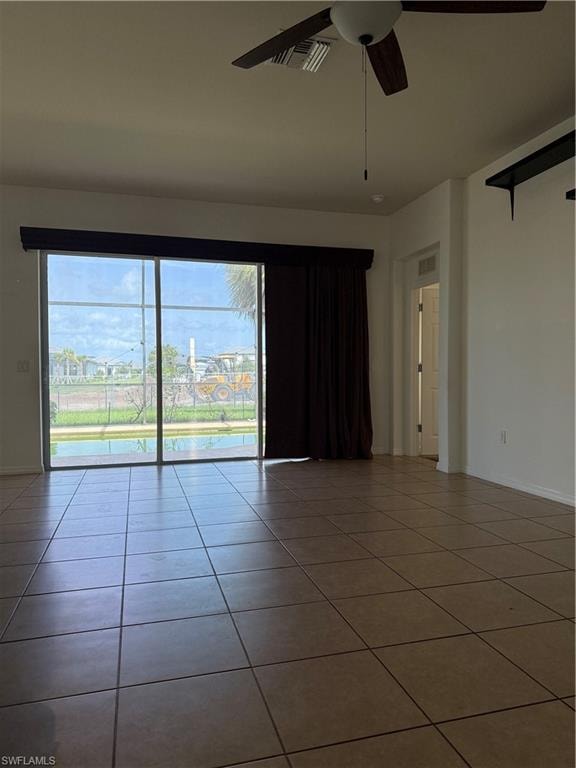 Spacious interior with large format tile flooring and a ceiling fan