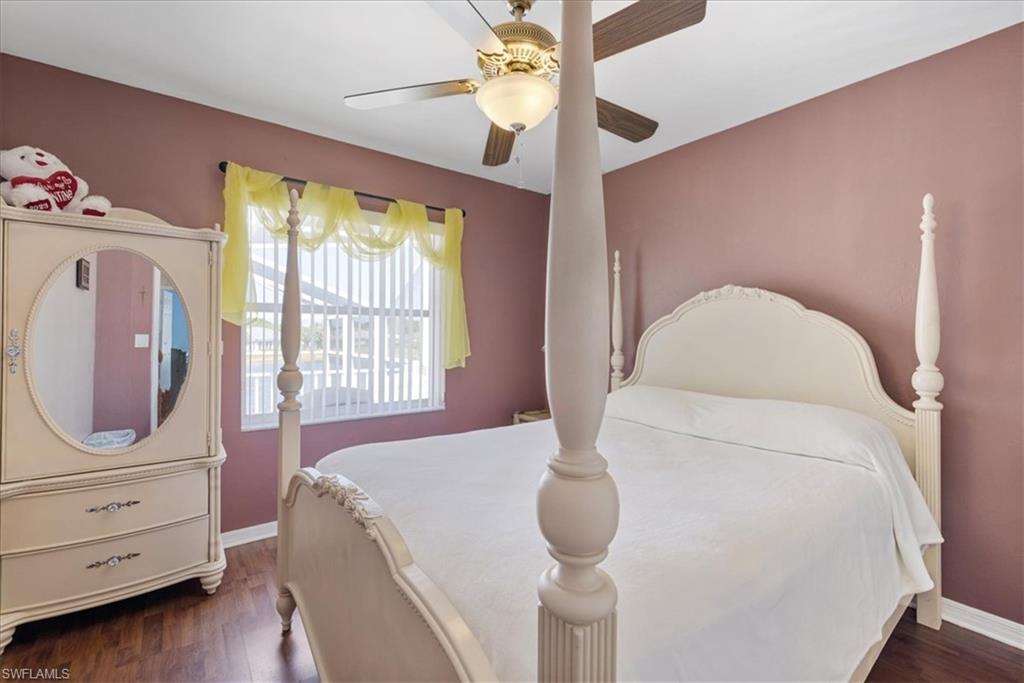 Bedroom with baseboards, wood finished floors, and a ceiling fan