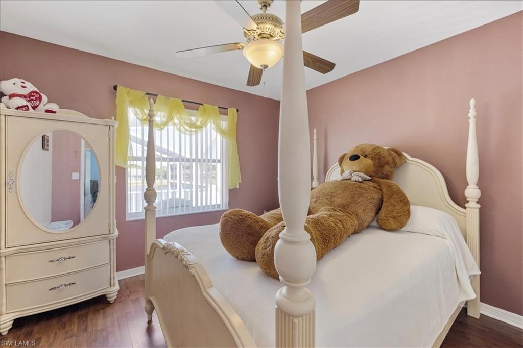 Bedroom featuring baseboards, wood finished floors, and ceiling fan