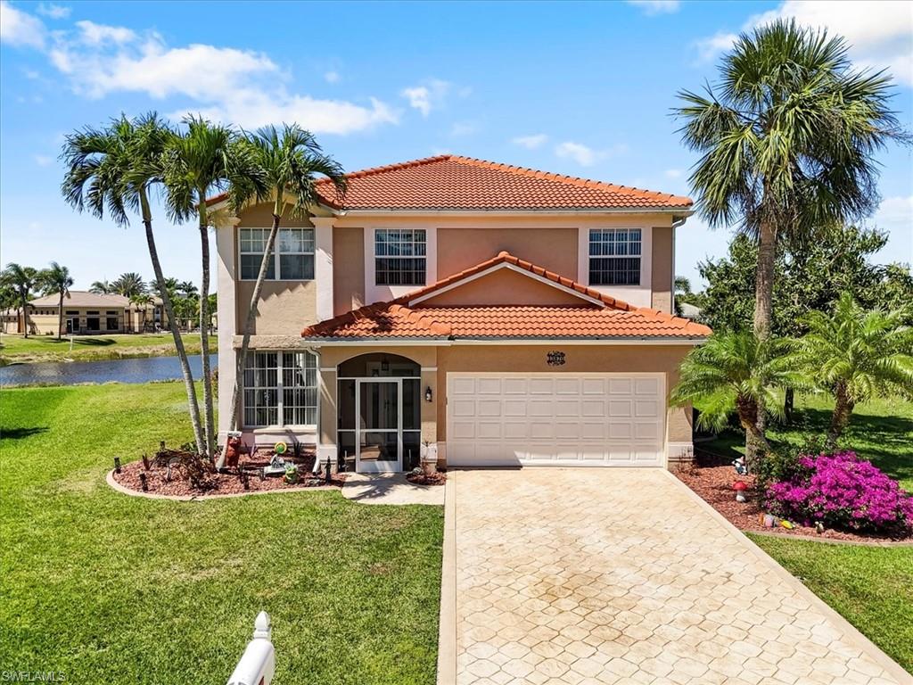 Mediterranean / spanish-style house featuring a water view, a tiled roof, decorative driveway, a front yard, and stucco siding