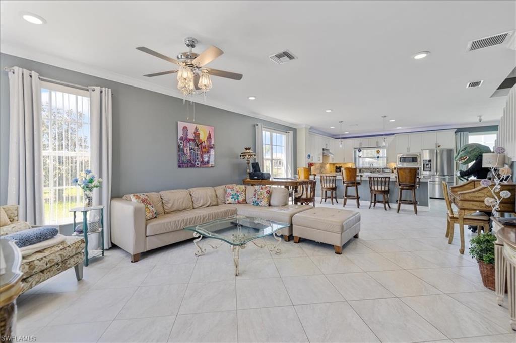 Living room featuring recessed lighting, crown molding, ceiling fan, and visible vents