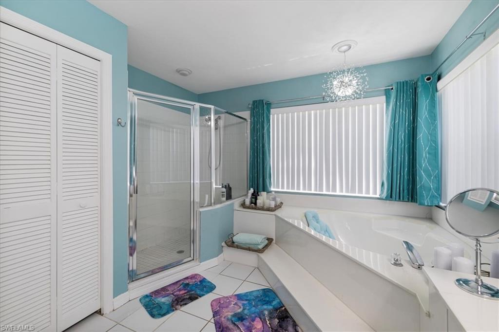 Full bathroom with a closet, a stall shower, tile patterned flooring, and a bath