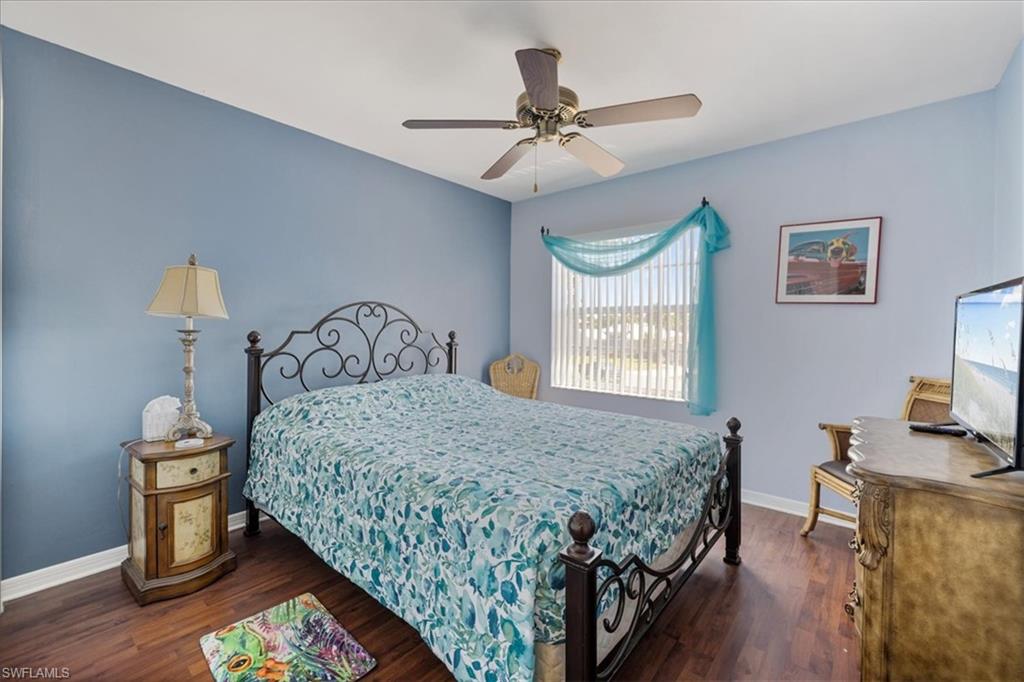 Bedroom featuring baseboards, wood finished floors, and ceiling fan