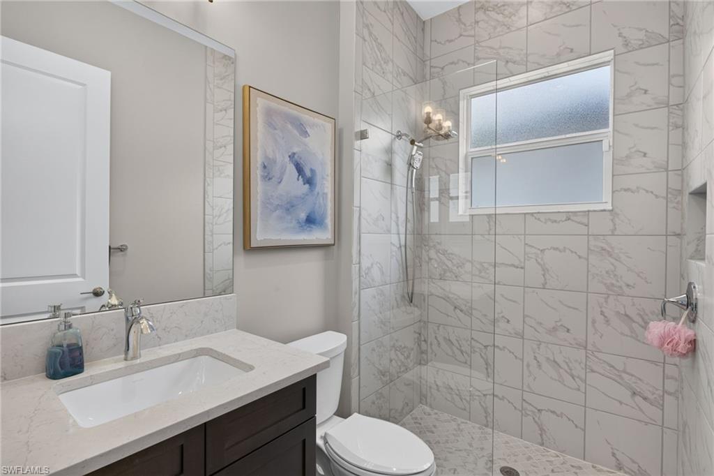 Contemporary bathroom featuring a dark wood-finish vanity with a light-toned countertop, an integrated rectangular sink, and a chrome faucet
