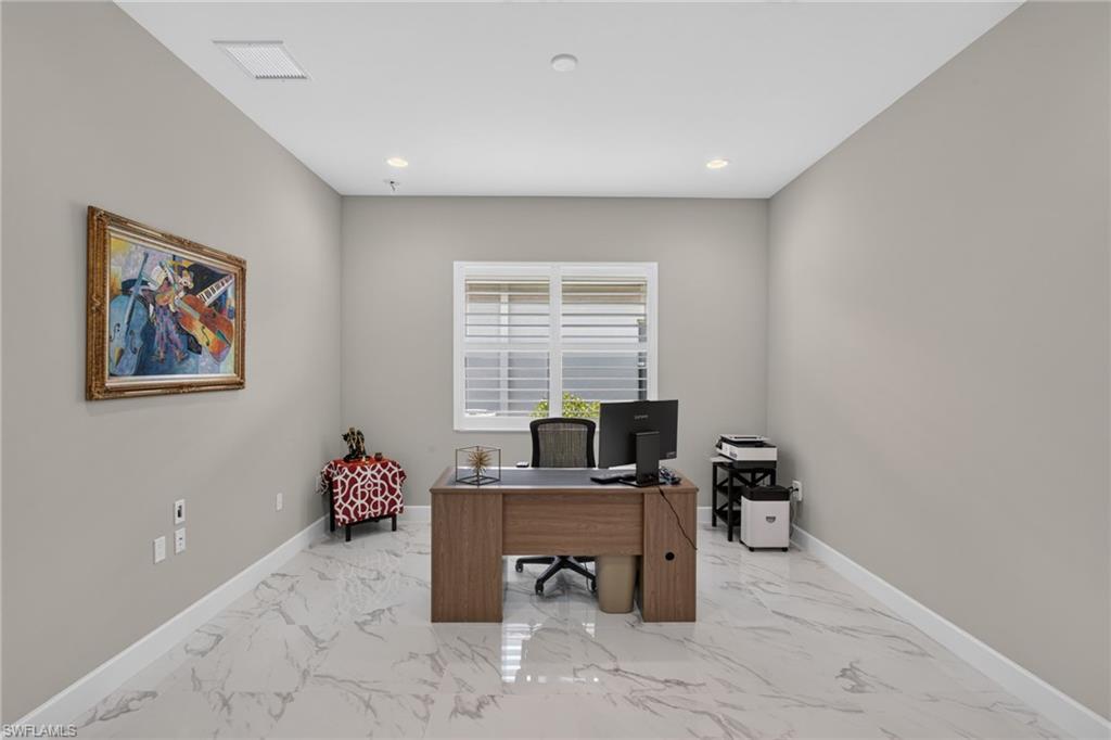 Bright interior room featuring a large window with white blinds, recessed lighting, and light-toned walls