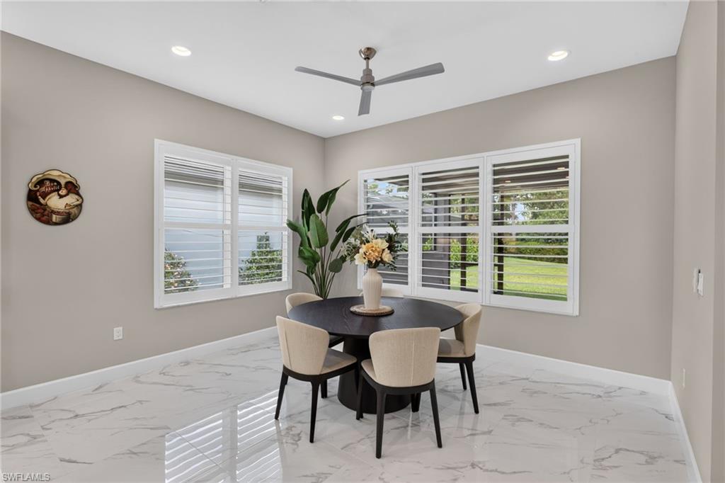 Bright interior space featuring large windows with white louvered shutters