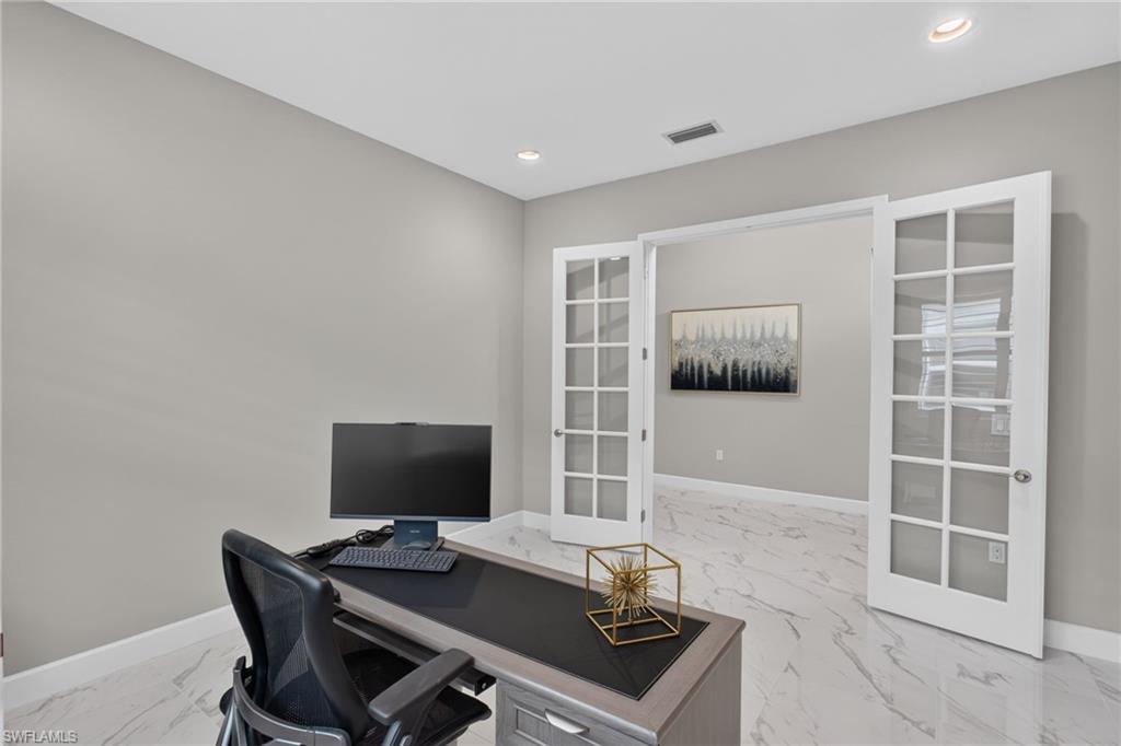 Spacious room featuring light gray walls, recessed lighting, and white baseboards