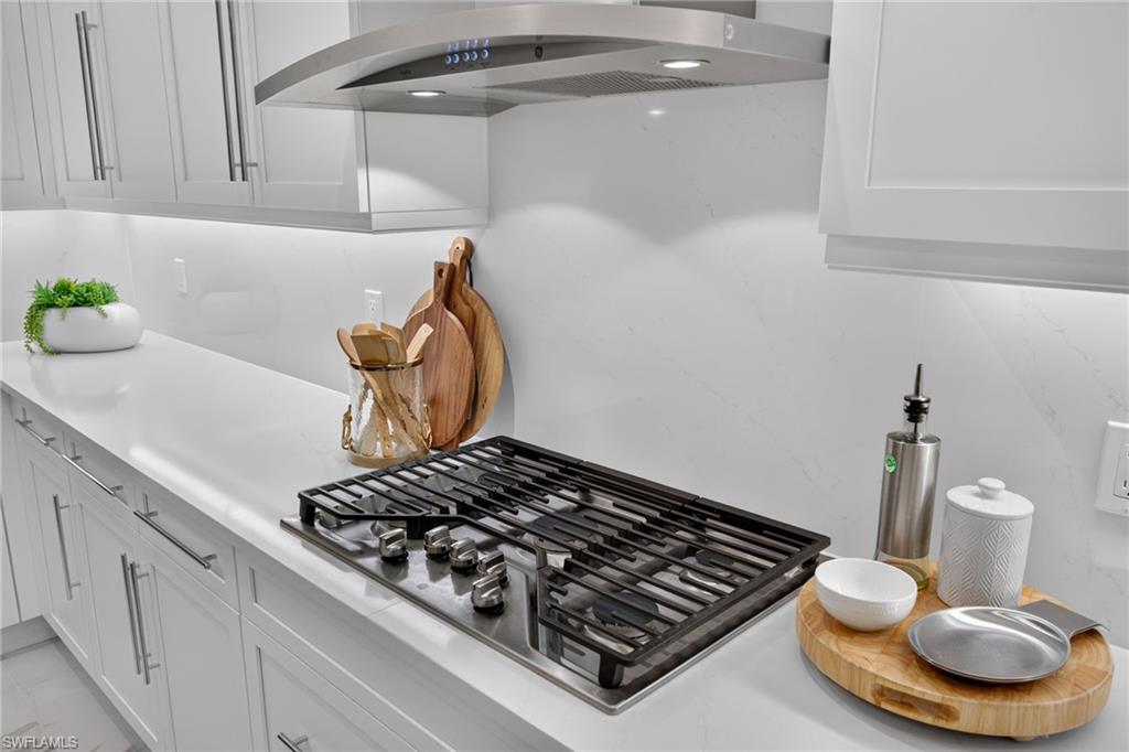 Integrated stainless steel gas cooktop with coordinating range hood