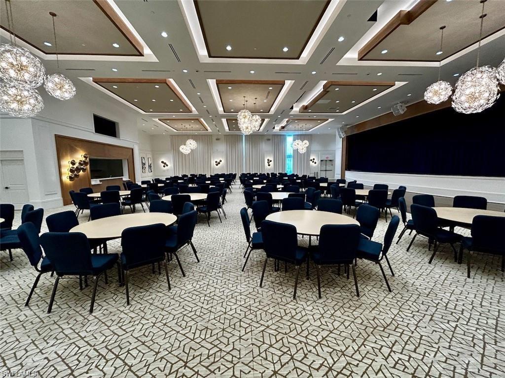 Spacious event room featuring a patterned carpet, recessed lighting, and multiple decorative pendant light fixtures