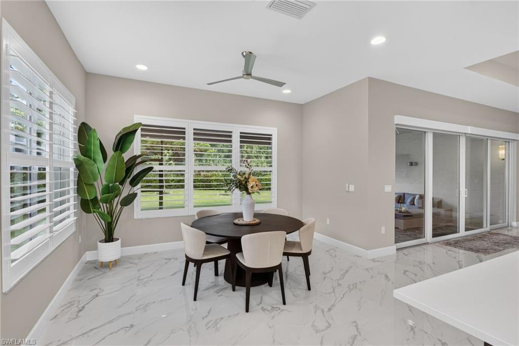 Open-concept dining area featuring large windows with plantation shutters, tile flooring, a contemporary ceiling fan, recessed lighting, and sliding glass doors