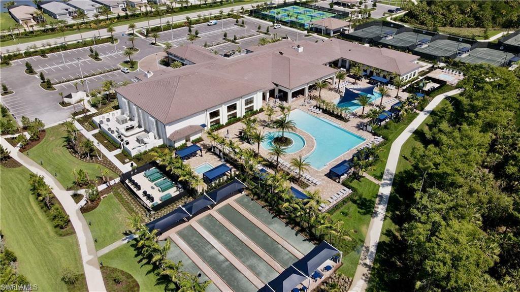 Community clubhouse with multiple swimming pools, extensive patio areas, bocce ball courts, and tennis courts