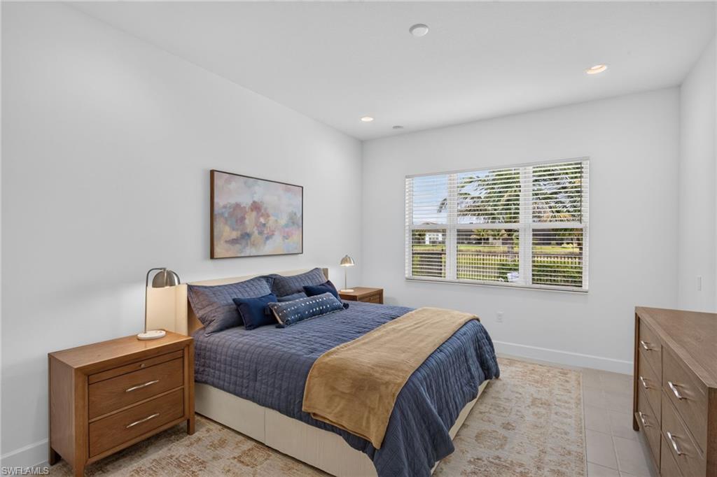 Spacious room featuring a large window with blinds, recessed lighting, and tile flooring