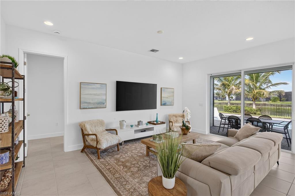 Spacious living area featuring large format tile flooring, recessed lighting, and direct access to an outdoor patio through sliding glass doors