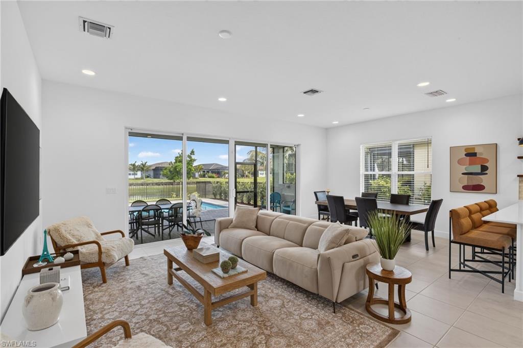 Open-concept living space featuring sliding glass doors to the outdoor area, recessed lighting, and tile flooring