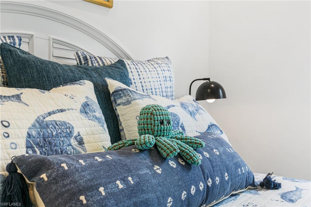 White paneled headboard with an arched top, featuring a built-in wall sconce with a matte black fixture