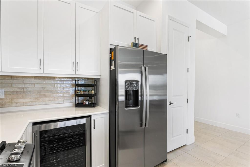 Modern kitchen featuring white shaker cabinetry and a stainless steel side-by-side refrigerator