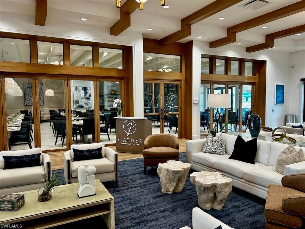 Spacious common area featuring wood-finish ceiling beams, recessed lighting, and a textured area rug