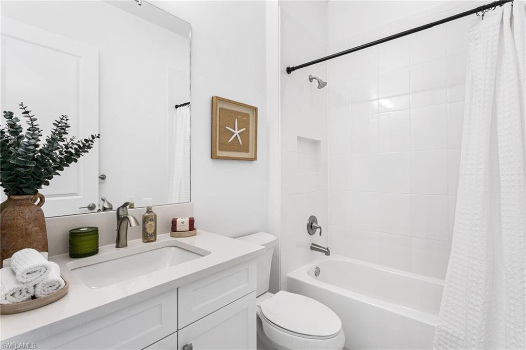 White bathroom featuring a single vanity with an integrated sink and light-toned countertop