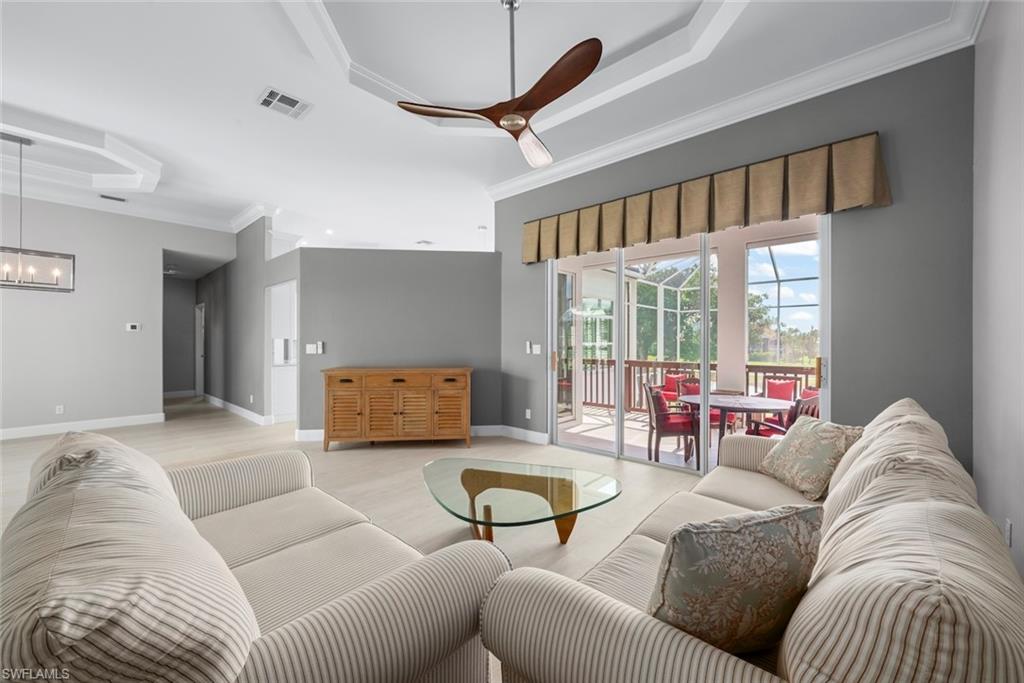 Expansive living area with tray ceilings and crown molding