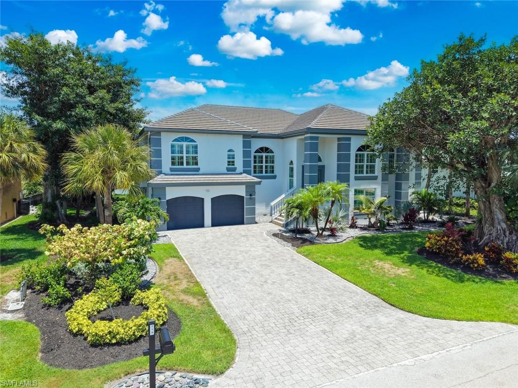 Two-story stucco residence featuring a tile roof and two-car garage
