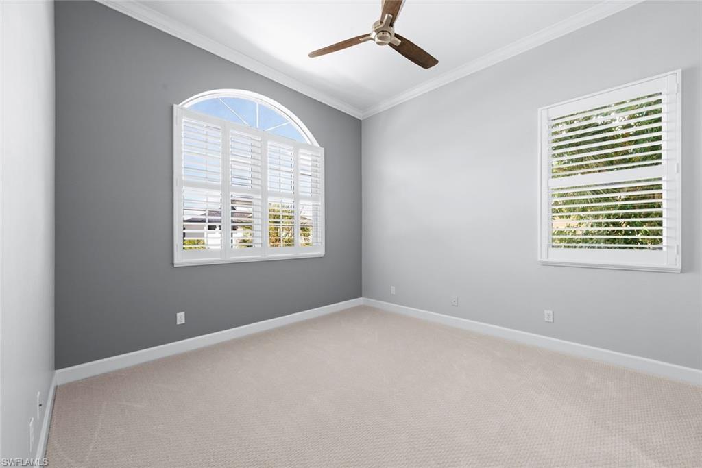 Spacious room featuring neutral carpeting and a ceiling fan