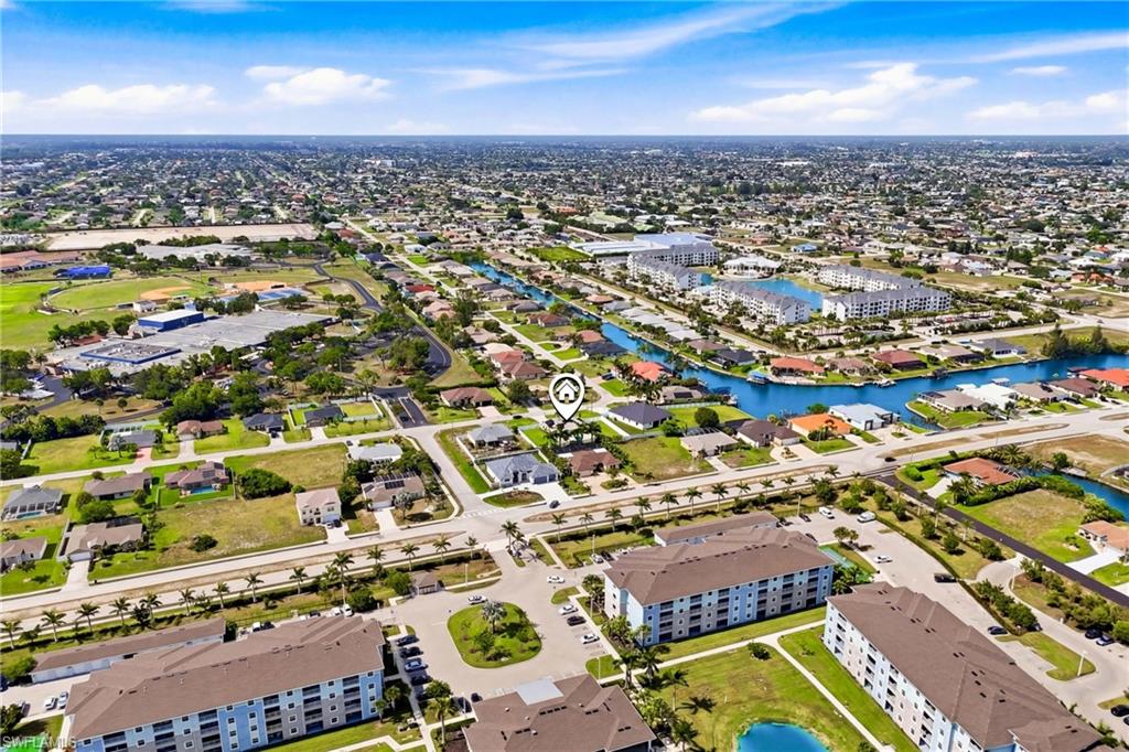 Aerial view of the surrounding neighborhood showcasing the established community, nearby homes, and the property’s setting within a desirable residential area.