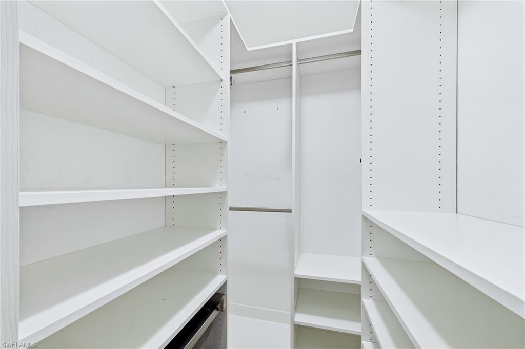 Custom-designed walk-in closet offers exceptional organization with built-in shelving, drawers, and dedicated storage solutions.