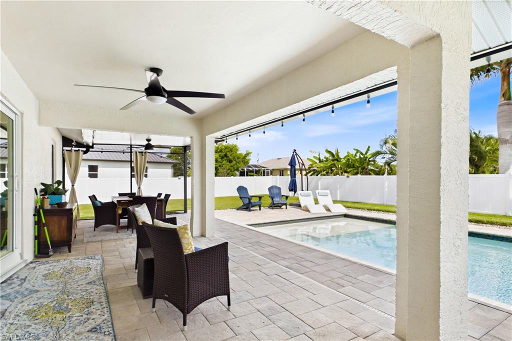 STUNNING! The whole back yard is like your own private resort! Extensive patio, pavers green grass and tons of room on both sides of the home!