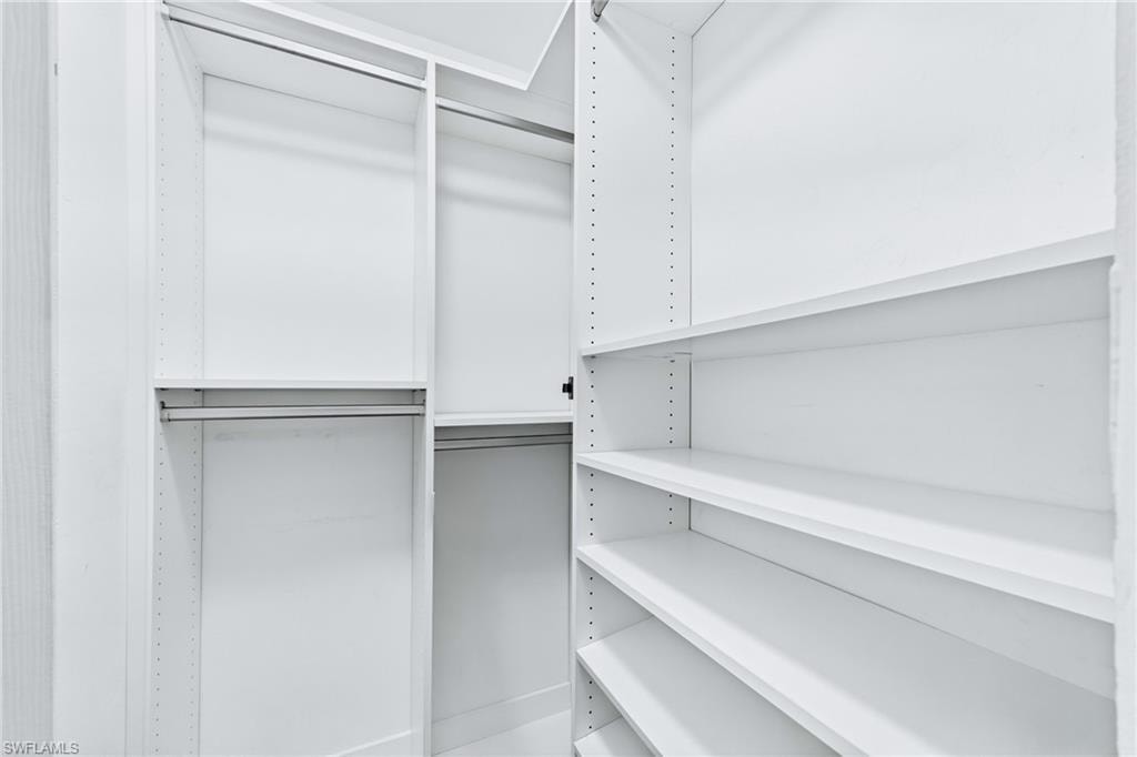 Spacious walk-in closet features professional organization systems designed to accommodate an extensive wardrobe with ease.