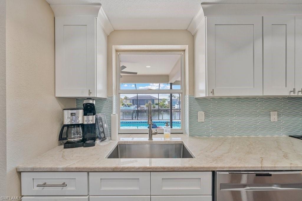 White shaker cabinetry paired with light-toned countertops and a stainless-steel undermount sink