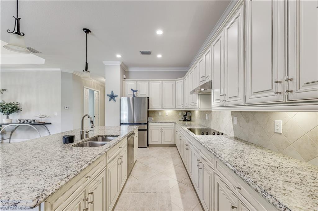 Gourmet kitchen featuring white cabinetry, light granite countertops, stainless steel appliances, a double basin sink, and a tiled backsplash