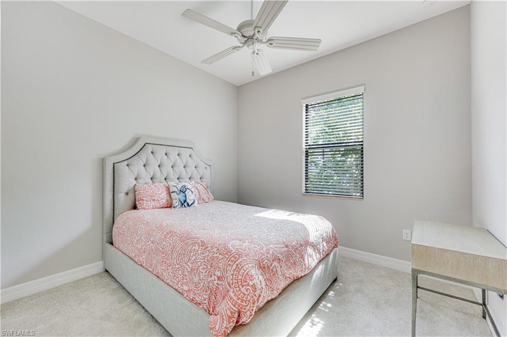 Carpeted room featuring a window with blinds, a ceiling fan, and light-toned walls