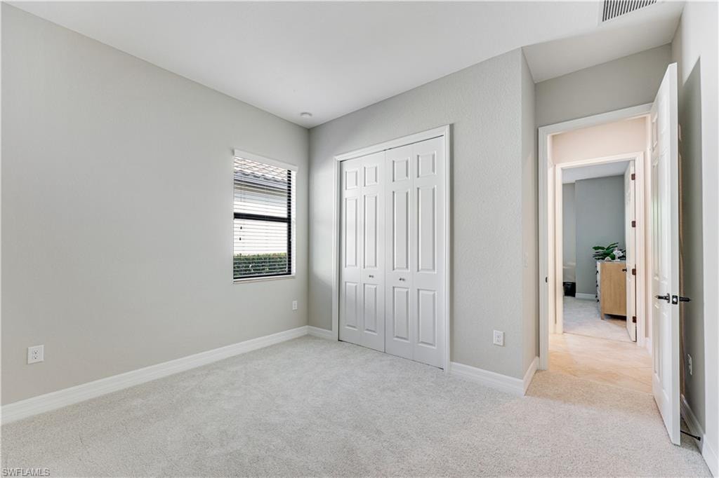 Carpeted room with a double bi-fold closet, single window with blinds, and light-toned wall paint