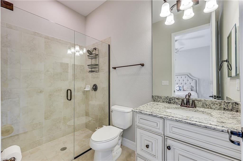 Shower with clear glass enclosure and light-toned tile surround