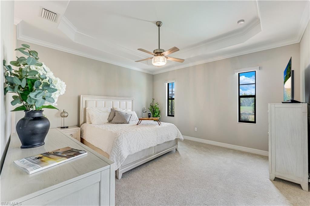 Spacious bedroom featuring a tray ceiling, recessed lighting, and a ceiling fan