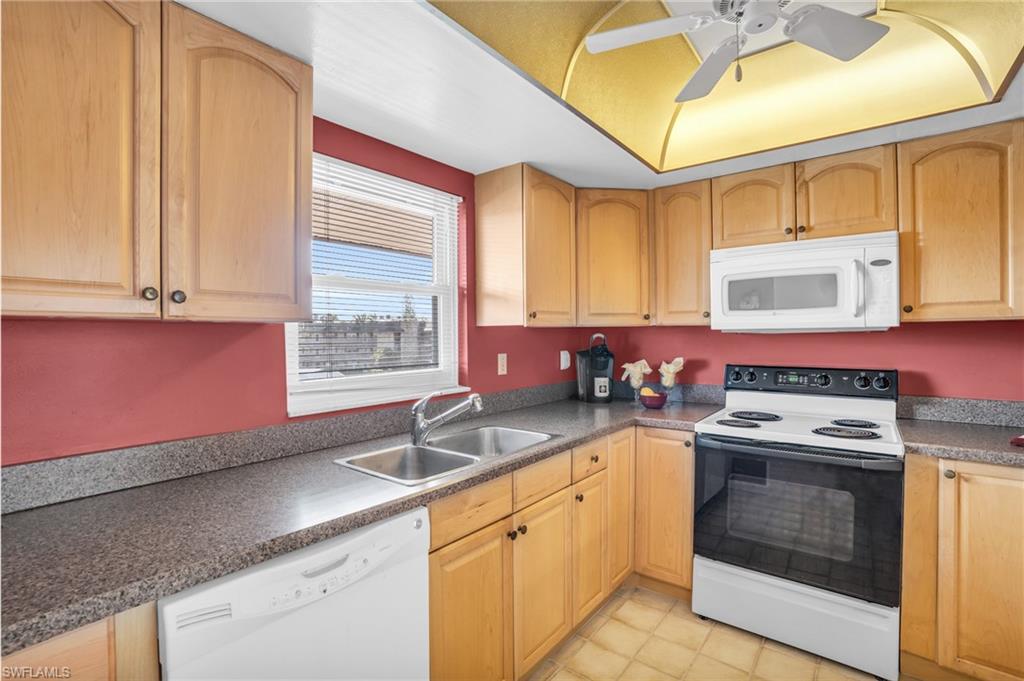 UPDATED WARM WOOD CABINETRY, COORDINATING COUNTERS, AND NEWER IMPACT WINDOW...