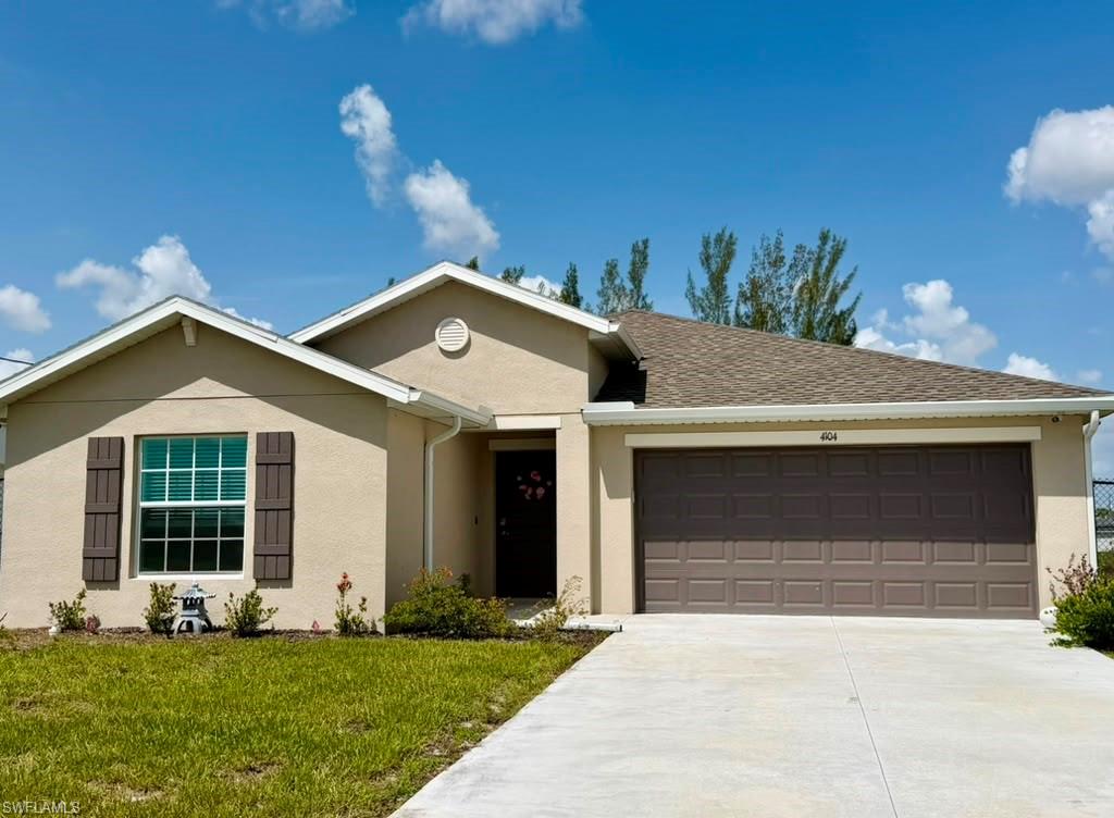 Contemporary stucco exterior with an attached garage, paved driveway, and decorative window shutters
