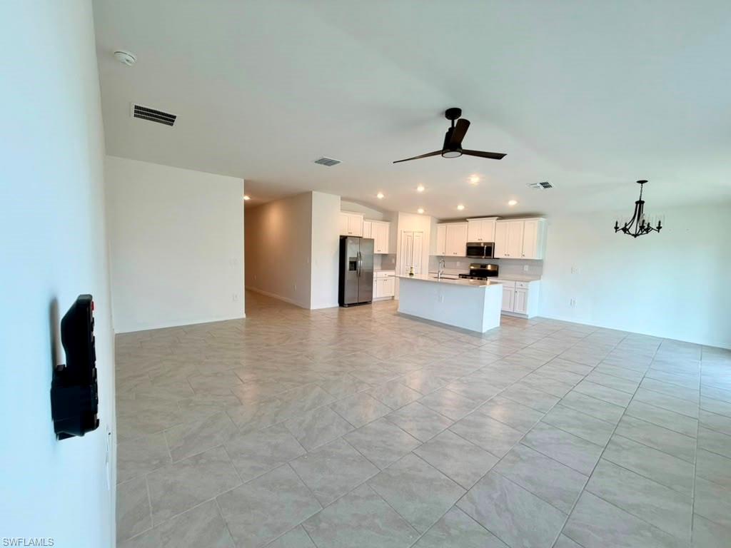 Open-concept living area featuring light-toned tile flooring throughout