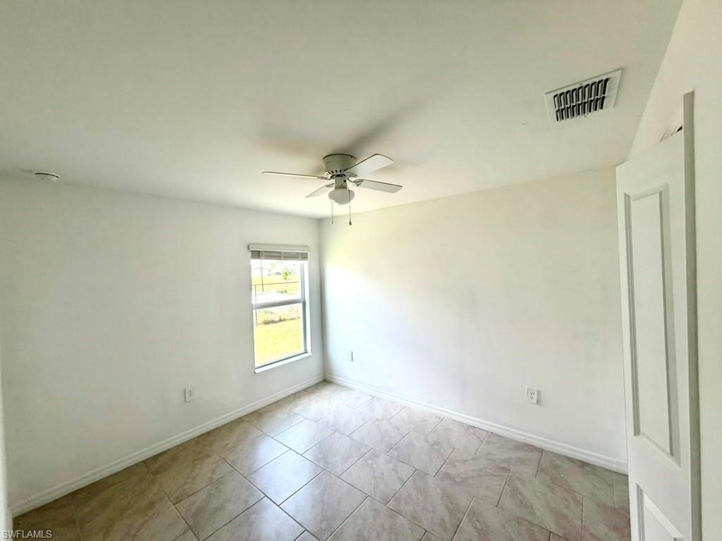 Room featuring neutral-toned tile flooring and white walls