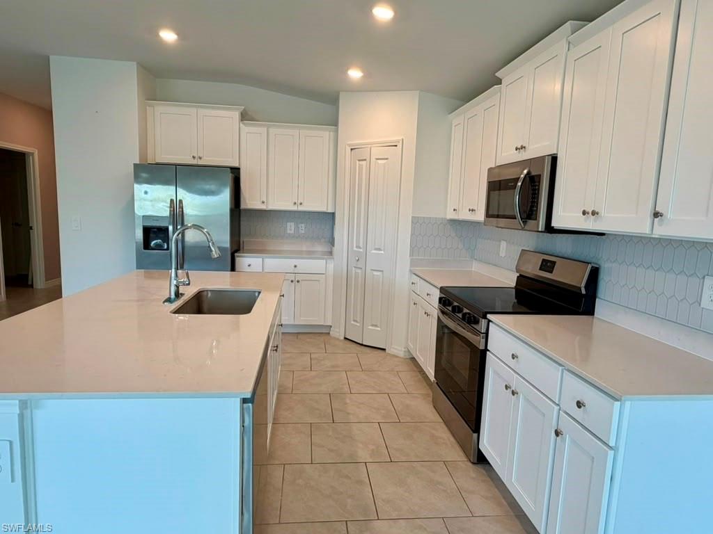 Kitchen featuring a large island with an undermount sink and gooseneck faucet