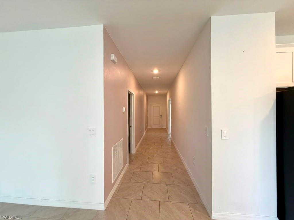 Hallway with tiled flooring and recessed lighting