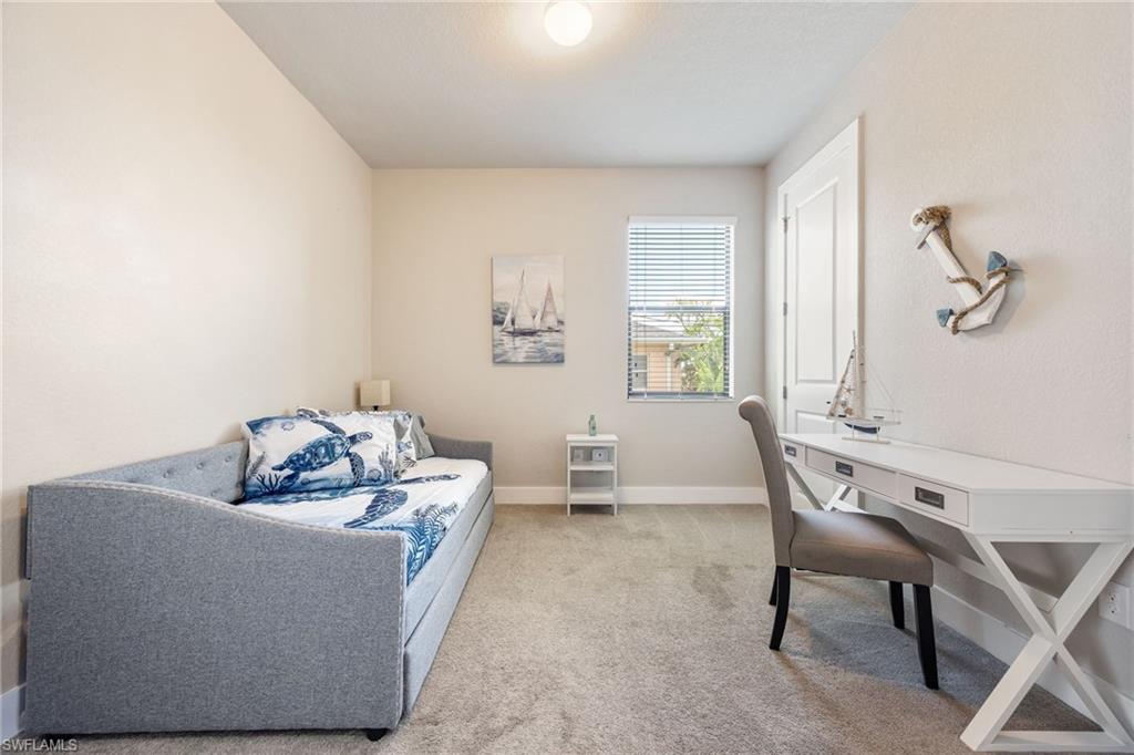 Carpeted room featuring a white paneled door, a single window with blinds, and light-colored walls