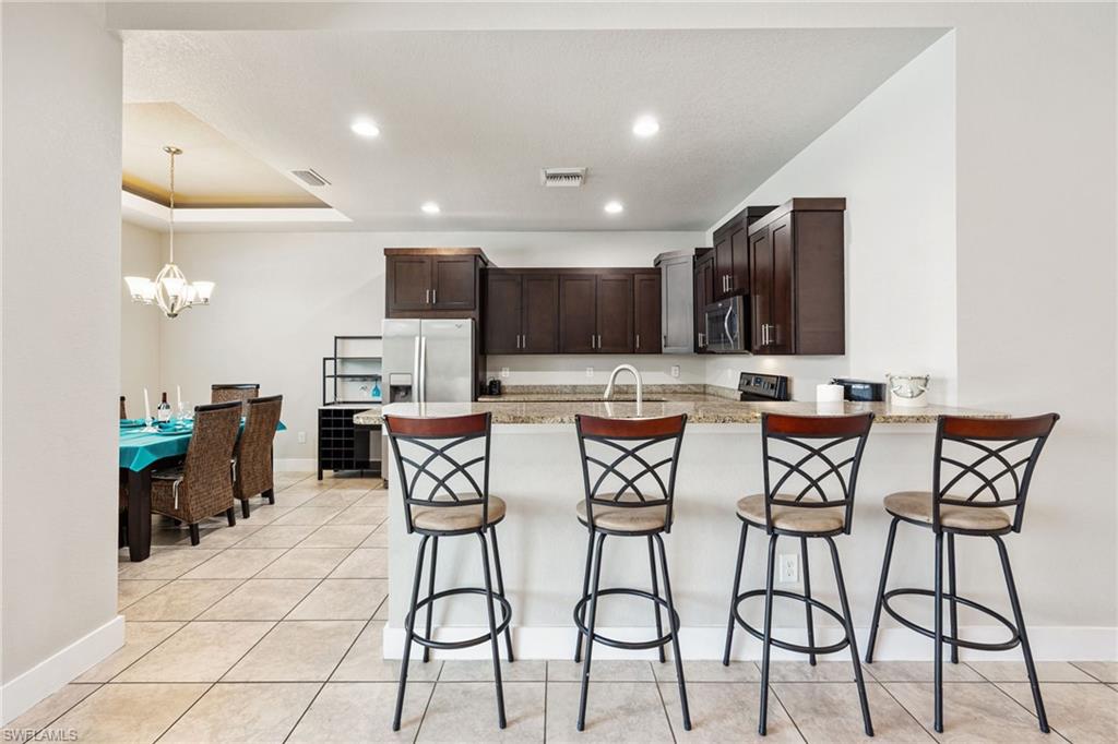 Kitchen featuring dark wood cabinetry, light-toned countertops, and stainless steel appliances
