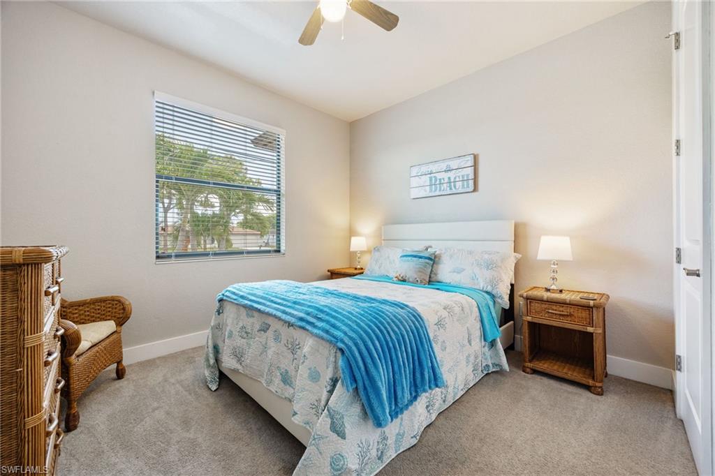 Bedroom featuring a ceiling fan, window with blinds, and light-toned carpet flooring