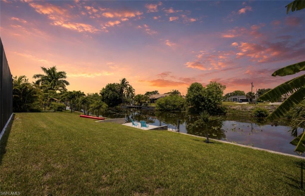 Expansive manicured lawn with mature tropical landscaping
