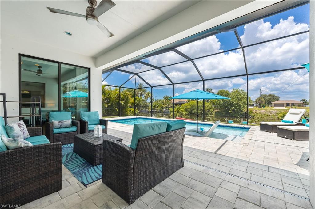 Screened patio with a ceiling fan, sliding glass doors, and a paver deck