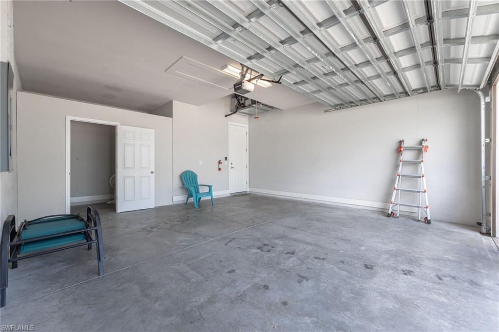 Spacious garage featuring a concrete floor and a automatic garage door opener