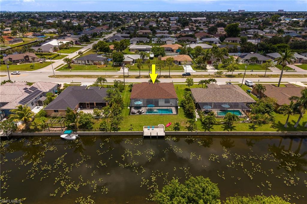 Waterfront property featuring a private boat dock, screened-in pool, and integrated patio